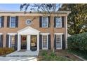 Charming brick townhome featuring black shutters and front door wreath at 1101 Collier Nw Rd # V6, Atlanta, GA 30318
