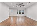 Spacious living room featuring gleaming hardwood floors, a ceiling fan, and bright windows at 113 Ambridge Ct, Lawrenceville, GA 30044
