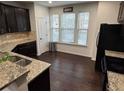 Kitchen showcasing granite countertops, stainless steel appliances, and dark wood flooring at 1957 Paxton Sw Dr, Lilburn, GA 30047