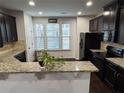 Kitchen with granite countertops, dark cabinets, and stainless steel appliances at 1957 Paxton Sw Dr, Lilburn, GA 30047