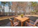 Backyard patio area with table and chairs surrounded by mature trees at 324 Mary Dr, Mcdonough, GA 30252