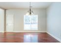 Bright dining room with hardwood floors and a large window at 129 Janney Cir, Mcdonough, GA 30253