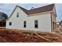 Side elevation of new home showing the white vinyl siding, dark trim, and lush lawn at 1937 Pucketts Sw Dr, Lilburn, GA 30047