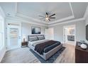 Relaxing main bedroom featuring a tray ceiling, ensuite bathroom, and exterior door at 169 Alaina Rd, Holly Springs, GA 30115