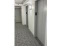 Clean and bright hallway with elevators and carpet flooring at 1280 W Peachtree Nw St # 1013, Atlanta, GA 30309