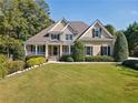 Beautiful home with a well-maintained lawn, complemented by mature landscaping and a covered porch at 3420 Aviary Ln, Acworth, GA 30101