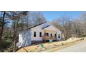 Inviting home featuring white siding, a cozy front porch, and a serene, natural setting at 41 Walnut Trl, Cartersville, GA 30121