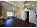 Spacious living room featuring vaulted ceilings, modern fan, wood floors, and stairs at 1153 Village Main St, Stone Mountain, GA 30088
