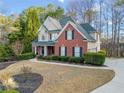 Inviting two-story home with a well-manicured lawn, mature trees, and a side-entry garage at 2007 Woodside Park Dr, Woodstock, GA 30188