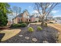Inviting two-story home with a well-manicured lawn, mature trees, and a side-entry garage at 2007 Woodside Park Dr, Woodstock, GA 30188