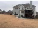 Back of house with two-story deck, patio, and fenced yard at 105 Kenmare Row, Tyrone, GA 30290