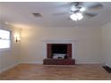 Living room with hardwood floors, brick fireplace and ceiling fan at 10155 Twin Oaks Sw Dr, Covington, GA 30014