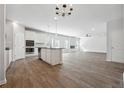 Open-concept kitchen featuring white cabinets, stainless steel appliances, and a large island at 257 Orwell Dr, Social Circle, GA 30025