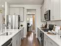 Kitchen showcasing stainless steel appliances, modern white cabinets, and eat-in dining area at 6900 Winchester Pl, Fairburn, GA 30213