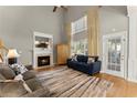 Bright living room with soaring ceilings, a cozy fireplace, large windows, and hardwood floors at 2352 Kelman Pl, Dacula, GA 30019