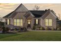 Charming brick home at dusk features a manicured lawn, black shutters, and welcoming front door at 514 Perdue Trl, Canton, GA 30115