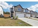 Charming two-story townhome with a brick and stone facade, attached garage, and well-manicured lawn at 273 Bald Ave, Stockbridge, GA 30253