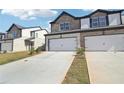 Charming two-story townhome with a brick and stone facade, attached garage, and well-manicured lawn at 273 Bald Ave, Stockbridge, GA 30253