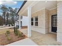 Close-up of a home's covered front porch showing the brick siding, white columns and a dark front door at 291 Martin Spring Rd, Lawrenceville, GA 30045