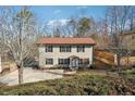 Charming two-story home with neutral siding, black shutters, mature trees, and a private driveway at 3683 Rolling Pl, Conley, GA 30288