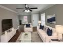 Bright living room with hardwood floors, comfy seating, and large TV at 721 Yale Sw Pl, Atlanta, GA 30315