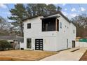 Beautiful two-story home with a modern exterior, black trim, balcony, and a concrete driveway at 2208 Baker Nw Rd, Atlanta, GA 30318