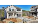 Charming two-story home with grey siding, brick accents, a covered porch, and a two-car garage at 688 Calvet Way, Cumming, GA 30041