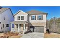 Charming two-story home with grey siding, brick accents, a covered porch, and a two-car garage at 688 Calvet Way, Cumming, GA 30041