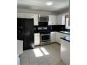 Kitchen features white cabinets, black countertops, and stainless steel appliances at 2254 Wellington Cir, Lithonia, GA 30058