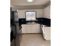 White kitchen cabinets, black countertops, and stainless steel appliances at 2254 Wellington Cir, Lithonia, GA 30058