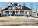 Two-story house with wrap-around porch, gray siding, and red shutters, detached garage at 447 Cotton Mill Dr, Hiram, GA 30141