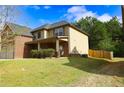 This home offers great curb appeal with a well-kept lawn, brick accents, and a wooden fence at 7940 White Oak Loop, Lithonia, GA 30038