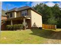 This home offers great curb appeal with a well-kept lawn, brick accents, and a wooden fence at 7940 White Oak Loop, Lithonia, GA 30038