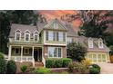 Two-story house with brick and green siding, a large front porch, and a two-car garage at 192 Chicopee Ne Dr, Marietta, GA 30060