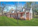 Brick house with a wraparound porch and green lawn at 3404 Mount Olive Rd, Atlanta, GA 30344