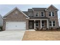 Charming two-story brick home with a two-car garage and a covered front entry at 714 Ocmulgee Xing, Locust Grove, GA 30248