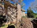 Side view of a brick home with mature trees and a small, fenced area at 3928 Potomac Nw Dr, Kennesaw, GA 30144