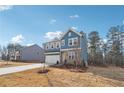 Charming two-story home with blue siding, stone accents, attached garage, and well-maintained landscaping at 7260 Eton Ln, Locust Grove, GA 30248