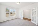 Bright, carpeted room with double doors and a large window offering plenty of natural light at 7260 Eton Ln, Locust Grove, GA 30248