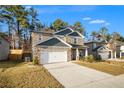 Two-story house with stone and gray siding, a two-car garage, and a landscaped yard at 7787 Richmond Trl, Fairburn, GA 30213