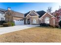House exterior with a large driveway and lawn at 2041 Democracy Dr, Buford, GA 30519