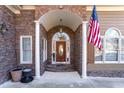 Elegant entryway with arched columns, stonework, and a wood door at 2041 Democracy Dr, Buford, GA 30519