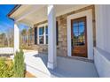 Welcoming front porch featuring stone accents, a wood door with glass, and a bright, covered entryway at 3330 Hillshire Dr, Cumming, GA 30028