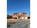 Well-maintained two-story home with a two-car garage, manicured lawn, and a long driveway at 575 Dunagan Dr, Lawrenceville, GA 30045