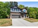 Charming two-story home featuring stone and siding exterior, manicured lawn and attached two-car garage at 4002 Adler Cir, Buford, GA 30519