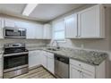 Modern kitchen with white cabinets, granite counters, and stainless steel appliances at 905 Fairburn Nw Rd, Atlanta, GA 30331