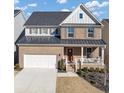 Two-story brick home featuring a covered porch, two car garage, and manicured landscaping at 4349 Northmark Ln, Buford, GA 30518