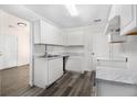 Bright kitchen featuring white cabinets, updated countertops, and modern flooring at 3884 Blue Granite Way, Conley, GA 30288