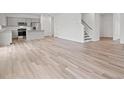 Spacious open-plan living area with hardwood flooring, a modern kitchen, and a staircase at 3340 Redwood Ct, Covington, GA 30016