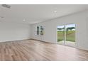 Bright living area featuring hardwood floors, sliding doors, and backyard views at 3340 Redwood Ct, Covington, GA 30016